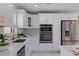 Close up of the bright kitchen with stainless appliances, white cabinets, and marble countertops at 145 174Th Terrace E Dr, Redington Shores, FL 33708