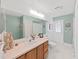 Well-lit bathroom featuring a single sink vanity, a large mirror, and tiled floors at 1472 Overland Dr, Spring Hill, FL 34608