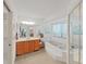 Bright bathroom featuring a soaking tub with a window, a sink, and cabinet with a mirrored closet at 1472 Overland Dr, Spring Hill, FL 34608