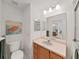 Bathroom with a toilet and sink with vanity, with a large mirror at 1472 Overland Dr, Spring Hill, FL 34608