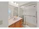 Bathroom featuring a shower with glass doors, a sink with vanity, and a large mirror at 1472 Overland Dr, Spring Hill, FL 34608