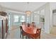 Bright dining room featuring a wood table, chandelier and large windows for natural light at 1472 Overland Dr, Spring Hill, FL 34608