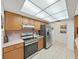 Well-lit kitchen with wood cabinets and stainless steel refrigerator and stove at 1472 Overland Dr, Spring Hill, FL 34608