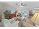 Bright and airy living room offers comfortable seating, a ceiling fan, and sliding glass doors leading to a pool area at 1472 Overland Dr, Spring Hill, FL 34608