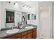 Bathroom featuring double sinks, wood cabinets, granite countertops and walk-in shower at 1614 E Nome St, Tampa, FL 33604