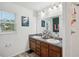 Bathroom with double sinks, wood cabinets, granite countertops and large mirror with decor at 1614 E Nome St, Tampa, FL 33604