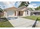 Single-story home featuring a driveway, garage, front porch, and well-manicured lawn at 1614 E Nome St, Tampa, FL 33604