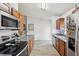 Galley kitchen with stainless steel appliances, wood cabinets, granite counters, and modern decor at 1614 E Nome St, Tampa, FL 33604