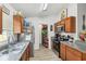 Galley kitchen with stainless steel appliances, wood cabinets, granite counters, and pantry at 1614 E Nome St, Tampa, FL 33604
