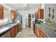 Galley kitchen with stainless steel appliances, wood cabinets, granite counters, and pantry at 1614 E Nome St, Tampa, FL 33604