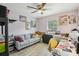 Bedroom converted to office with hardwood floors, ceiling fan, and a gray sofa at 1614 E Nome St, Tampa, FL 33604