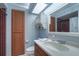 Bright bathroom features a skylight, wood cabinets, a large mirror and a tiled shower at 16247 Fringe Tree Dr, Spring Hill, FL 34610
