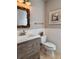 Cozy half bath features wainscoting, decorative mirror and sea shell art at 1720 Lighthouse S Ter # 8, South Pasadena, FL 33707