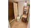 Bathroom featuring tiled shower with curtain, toilet, and decorative shelving with plants and towels at 1720 Lighthouse S Ter # 8, South Pasadena, FL 33707