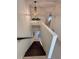 Staircase with chandelier and planter, leading to the lower level at 1720 Lighthouse S Ter # 8, South Pasadena, FL 33707