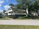 A three-story condo building with balconies, palm trees, green landscaping, and mature shade trees surrounding at 2583 Countryside Blvd # 3102, Clearwater, FL 33761