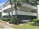 A three-story condo building with balconies, palm trees, and green landscaping with the windows looking out to a courtyard at 2583 Countryside Blvd # 3102, Clearwater, FL 33761