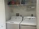 Efficient laundry room with washer, dryer, and shelving for organized storage at 2583 Countryside Blvd # 3102, Clearwater, FL 33761