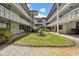 Courtyard with white balconies, manicured lawn, and a circular garden in the middle at 2612 Pearce Dr # 209, Clearwater, FL 33764