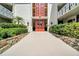 Building entrance featuring a stone walkway, red double doors, and lush landscaping, creating a welcoming entry at 2612 Pearce Dr # 209, Clearwater, FL 33764