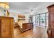 The large primary bedroom features hardwood floors, and a sliding glass door to the balcony at 2612 Pearce Dr # 209, Clearwater, FL 33764
