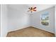 Cozy bedroom featuring a ceiling fan, neutral carpet, and a sunlit window at 312 Taxter Run Ln, Valrico, FL 33594