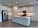 Modern kitchen with white cabinets, stainless steel appliances, and a central island at 31753 Griffin Sands Ln, San Antonio, FL 33576