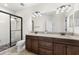 Modern bathroom features dual vanities, a large mirror, and a glass-enclosed shower at 3214 Painted Blossom Ct, Lutz, FL 33558