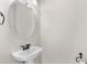 Clean, pedestal sink bathroom with a decorative mirror at 3214 Painted Blossom Ct, Lutz, FL 33558