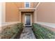 Inviting front entrance with a gray door, lush landscaping, and a stone pathway at 3214 Painted Blossom Ct, Lutz, FL 33558