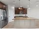 Modern kitchen with a large island, granite countertops, stainless steel appliances, and stylish pendant lights at 3214 Painted Blossom Ct, Lutz, FL 33558
