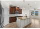 Well-lit kitchen featuring a granite island, stainless steel appliances, and modern pendant lights at 3214 Painted Blossom Ct, Lutz, FL 33558