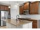 Kitchen featuring granite countertops, stainless steel appliances, a large island with a sink, and modern lighting at 3214 Painted Blossom Ct, Lutz, FL 33558