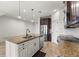 Open kitchen with a granite island, stainless steel appliances, and stylish pendant lighting at 3214 Painted Blossom Ct, Lutz, FL 33558