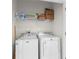 Functional laundry room equipped with a washer, dryer, and storage shelving at 3214 Painted Blossom Ct, Lutz, FL 33558