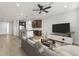 Open concept living room and kitchen with modern furniture, stainless appliances, and a ceiling fan at 3214 Painted Blossom Ct, Lutz, FL 33558