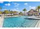 Community pool with clear blue water, surrounding lounge chairs, and a covered seating area at 3214 Painted Blossom Ct, Lutz, FL 33558