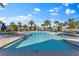 Community pool featuring palm trees, comfortable lounge chairs, and clear, inviting water at 3214 Painted Blossom Ct, Lutz, FL 33558