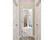 Hallway view to a bright bathroom with a glass-enclosed shower and tile flooring at 3822 Balcony Breeze Dr, Land O Lakes, FL 34638