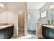 Bathroom showcasing granite countertops, dual vanities, glass shower with gray tiling, and black pebble floor at 3822 Balcony Breeze Dr, Land O Lakes, FL 34638