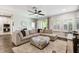 Spacious living room features a large sectional, plush rug, ceiling fan, and natural light from windows at 3822 Balcony Breeze Dr, Land O Lakes, FL 34638