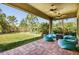 Covered patio boasts brick pavers, comfortable seating, and ceiling fans at 3822 Balcony Breeze Dr, Land O Lakes, FL 34638