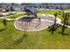 Aerial view of a modern playground with swings, play structures, and a shaded picnic area in a Gathering neighborhood at 3822 Balcony Breeze Dr, Land O Lakes, FL 34638