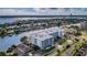 Aerial view of the modern condo building, showcasing the surrounding waterfront community and lush landscaping at 415 Island Way # 205, Clearwater Beach, FL 33767