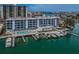 Aerial view featuring the condo building, waterfront access, boat docks, and community pool at 415 Island Way # 205, Clearwater Beach, FL 33767