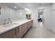 Bright bathroom features a long quartz countertop and wood cabinets, leading to a view of the Primary bedroom at 415 Island Way # 205, Clearwater Beach, FL 33767