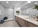 Contemporary bathroom featuring wood cabinets, double sinks, quartz countertop and a glass shower at 415 Island Way # 205, Clearwater Beach, FL 33767