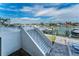 Exterior staircase with white railings that overlooks waterfront docks and boat lifts at 415 Island Way # 205, Clearwater Beach, FL 33767