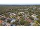 An aerial view displays a neighborhood with mature trees and houses with different roof colors at 4508 Compass Oaks Dr, Valrico, FL 33596