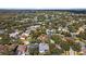 Wide aerial view of neighborhood featuring the home with solar panels surrounded by lush, mature trees and nearby lakes at 4508 Compass Oaks Dr, Valrico, FL 33596
